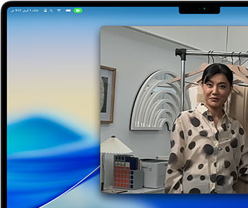 مكالمة فيديو على MacBook Pro تظهر فيها سيدة تعرض أقمشة لشخصين في المكالمة، بينما يحافظ نمط 'في الوسط' على بقائها في وسط الإطار أثناء تحركها