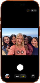 iPhone 17 Pro in Cosmic Orange, front, screen shows Center Stage front camera open with a group selfie of five people centered in frame