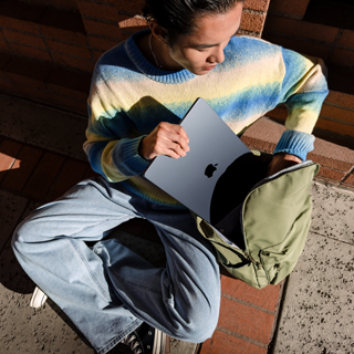 صورة أمامية لشخص يضع جهاز MacBook Air مقاس 15 إنش وهو مغلق داخل الحقيبة